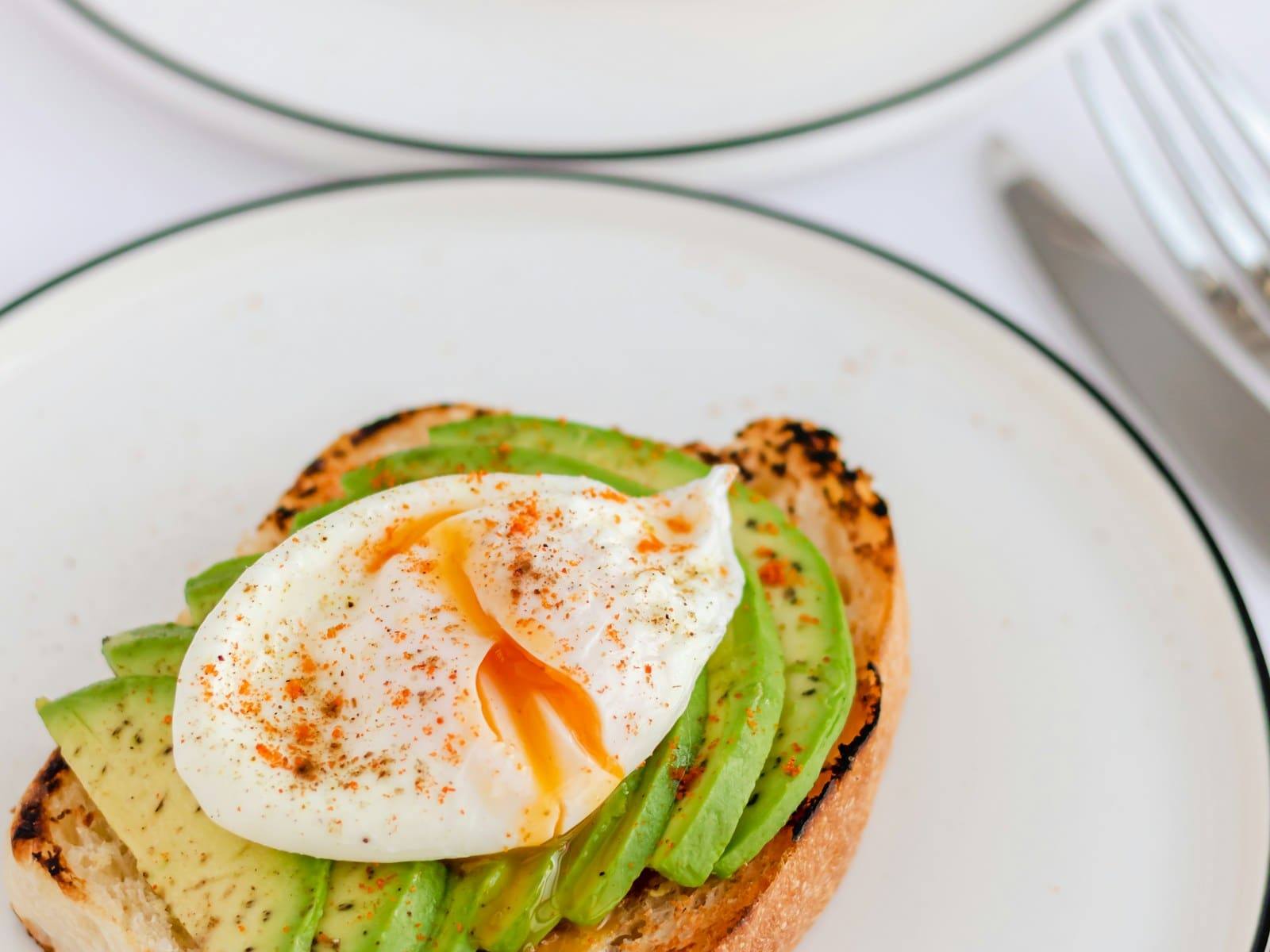 Smashed avocado on toast topped with a poached egg