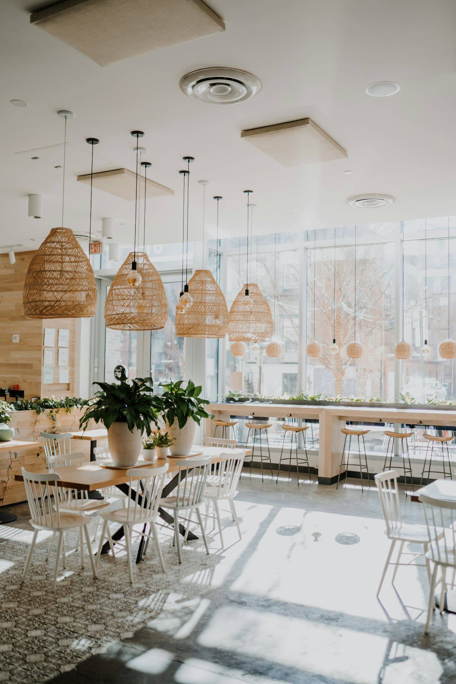 Light-filled dining room with woven pendant lights and plants