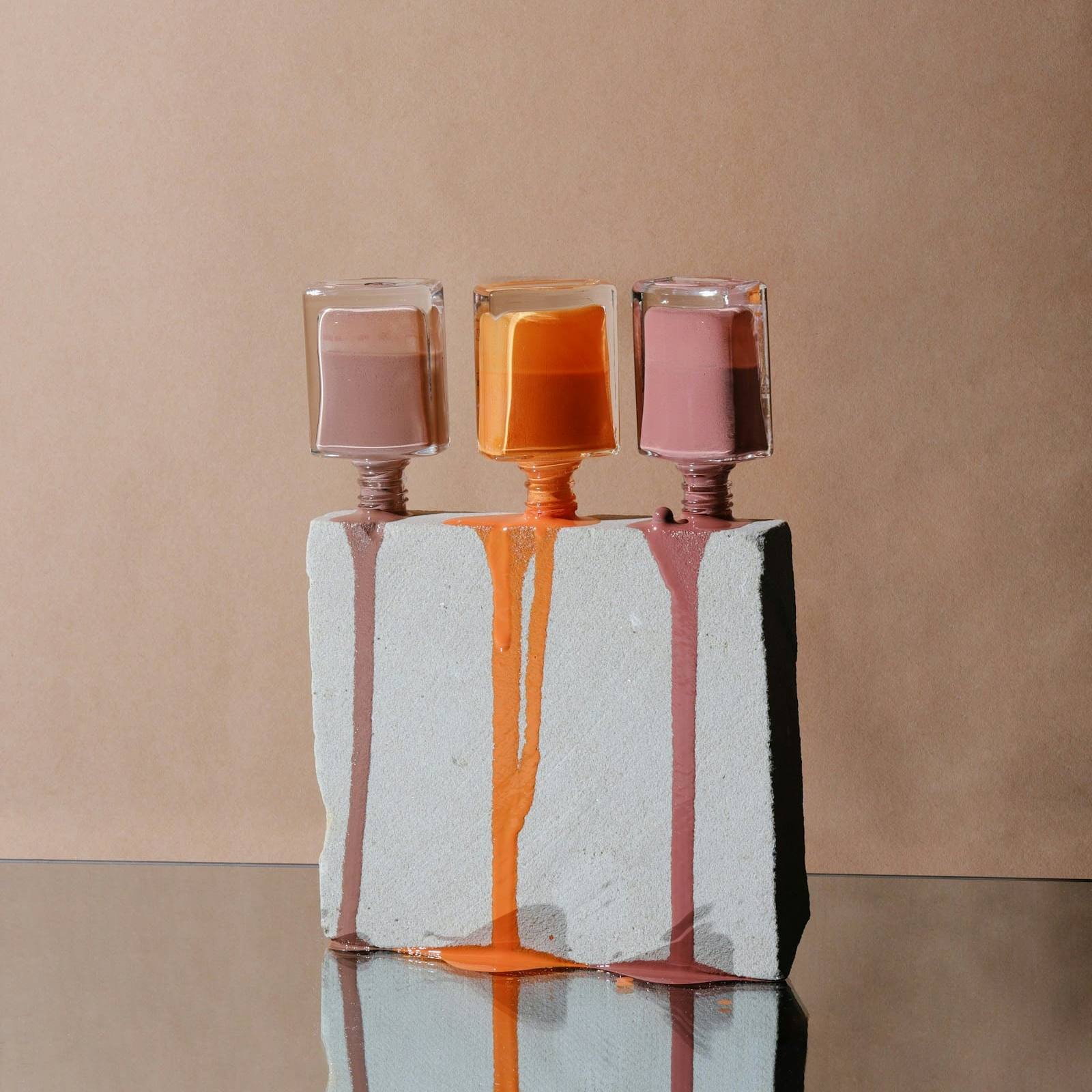 Three bottles of nail polish in blush, coral and rose